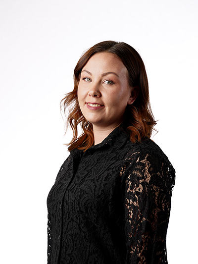 Kuva parturi-kampaaja Tiinasta poseeraamassa mustassa paidassa